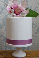 Simply styled 4”mini cake with sugar magnolia.