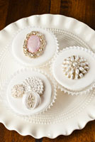 Fondant covered cupcakes with vintage brooches and pearls. 
