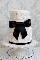 White cake with black ribbon. Cake design inspired by a UK designer.